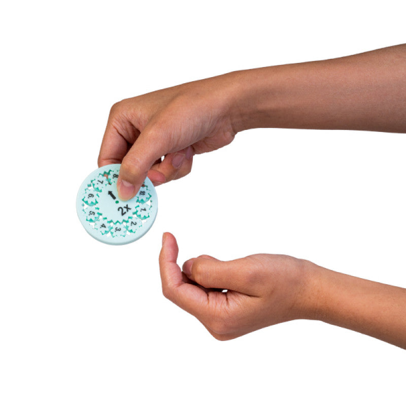 Child&#39;s hands holding a round light blue multiplication practice dial with numbers 1-9 and a spinning arrow