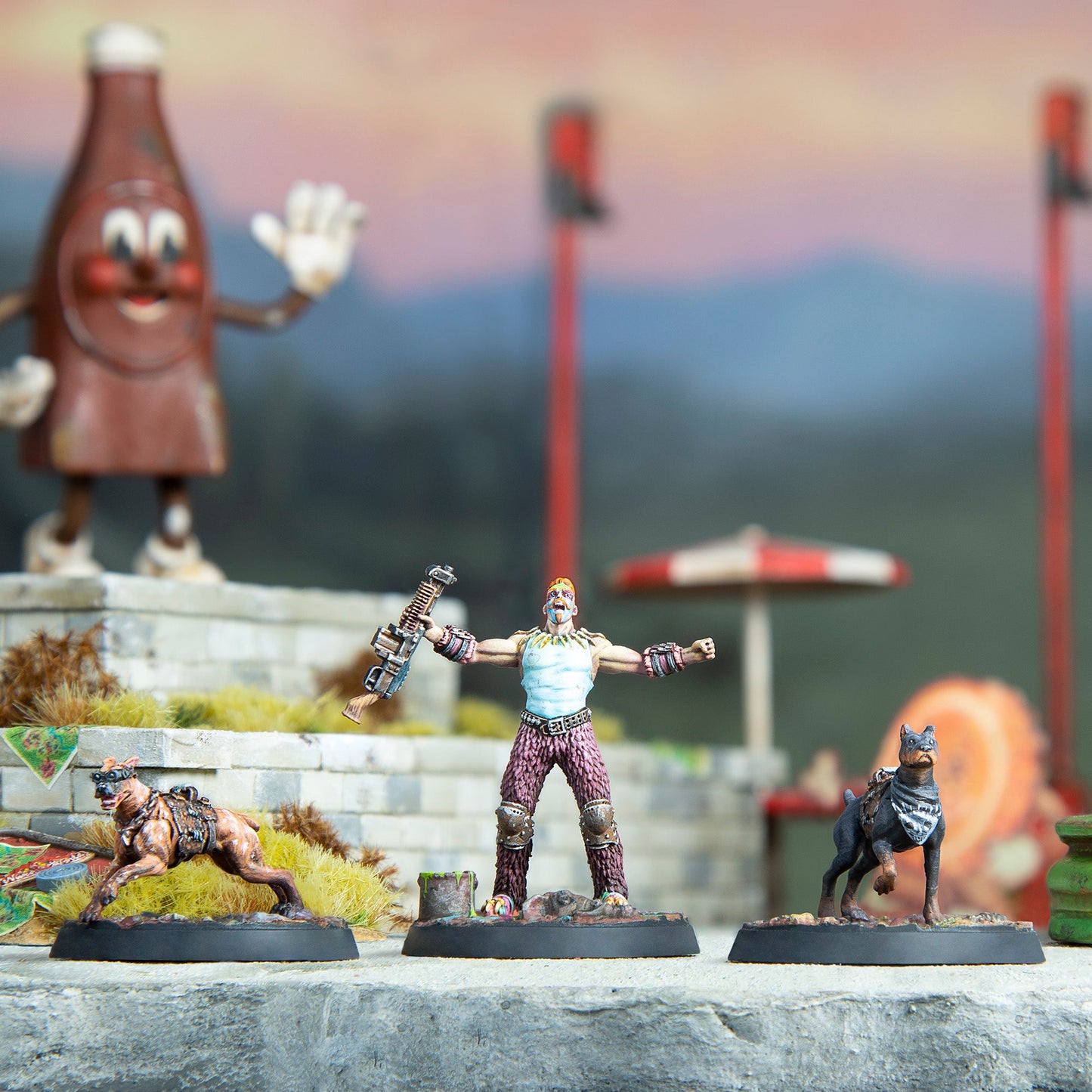 Painted Fallout miniatures: A warrior with arms outstretched, holding a weapon, flanked by two dogs
