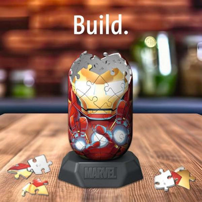 Partially assembled 3D Iron Man puzzle on a Marvel stand, with scattered pieces. "Build." text above