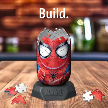 Partially assembled 3D Spider-Man puzzle on a Marvel stand with loose pieces. Text: "Build.