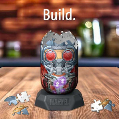 A Star-Lord helmet 3D puzzle, partly built with a glowing purple core, sits on a Marvel stand with loose pieces. Text: Build