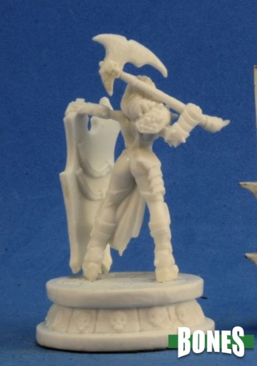 White miniature of an armored female warrior holding a large axe over her shoulder, standing on a skull-decorated base.