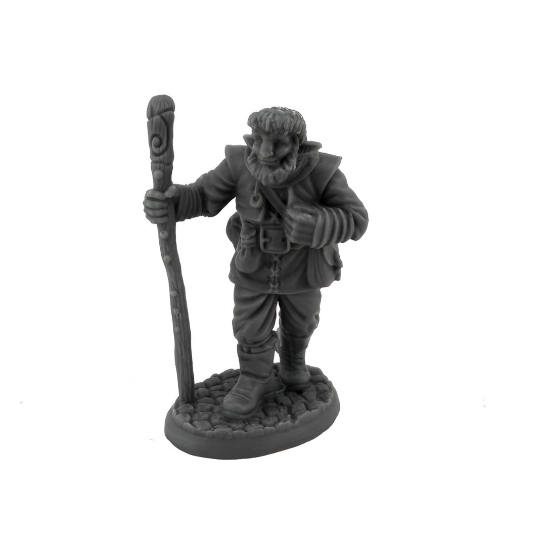 Grey miniature of a bearded gnome holding a carved staff, standing on a stone base