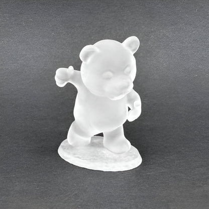 Frosted white bear figurine standing with left arm raised, thumb up, against a dark background