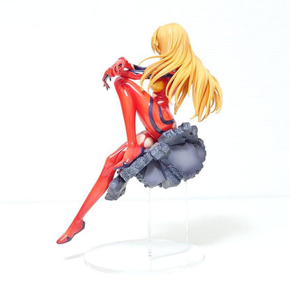 Side of Asuka Langley Soryu figure in red plugsuit with long orange hair, seated smiling on a grey rubble base