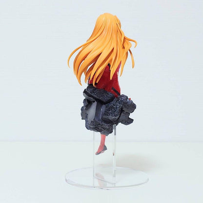 Back of Asuka Langley Soryu figure in red plugsuit with long orange hair, seated smiling on a grey rubble base 