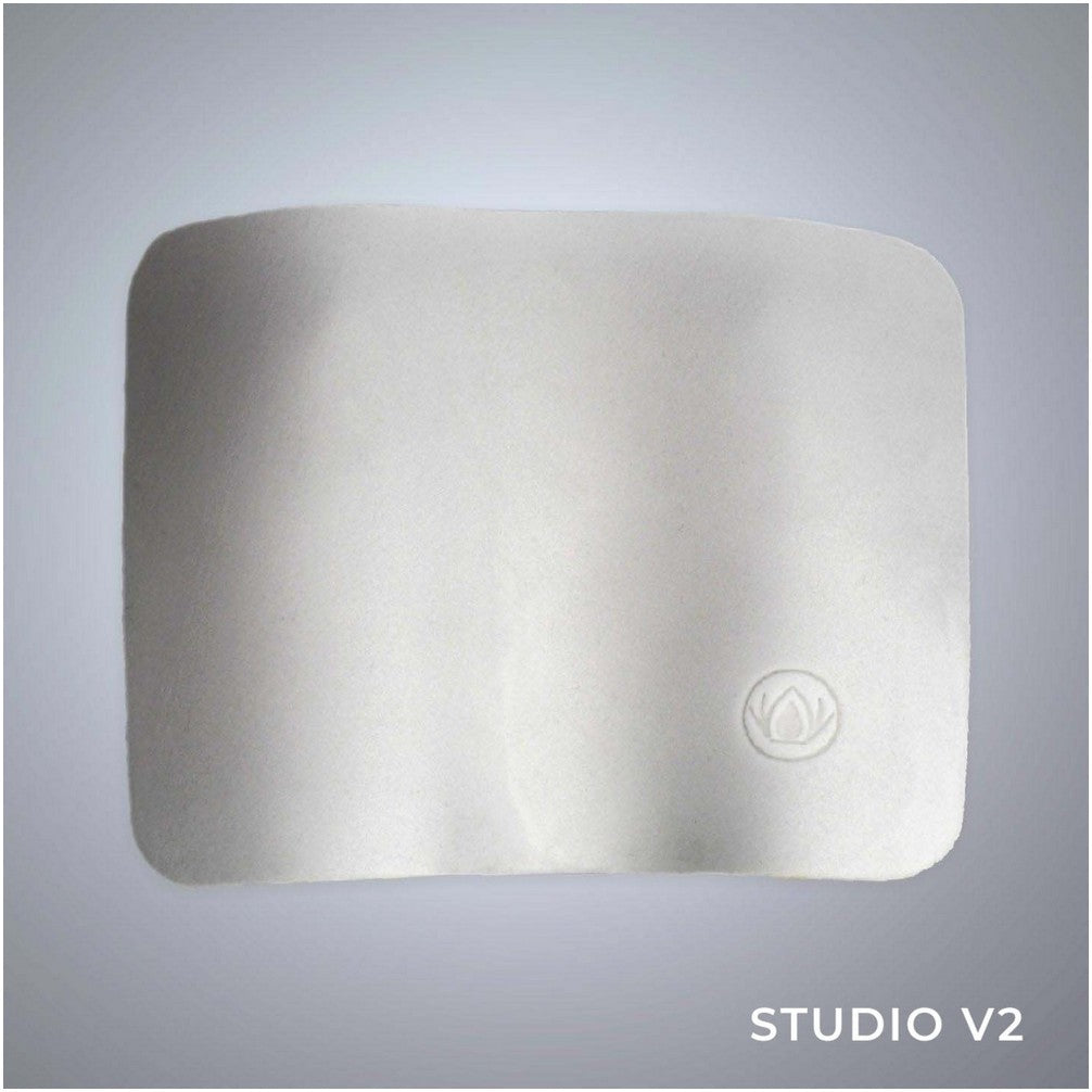 A soft white rectangular cushion with rounded corners, subtle embossed logo, and "STUDIO V2" text