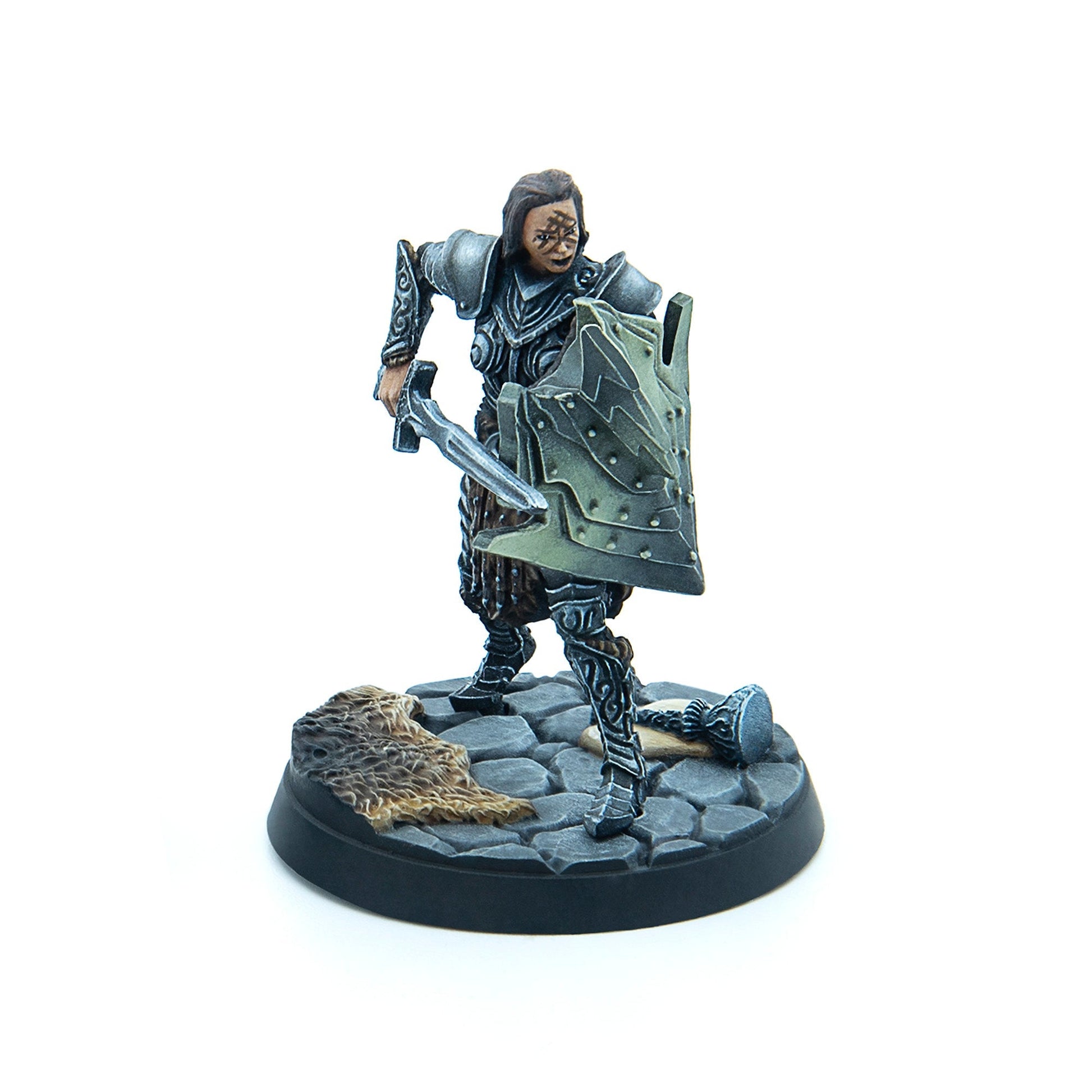 Miniature fantasy warrior in dark armor with face markings, holding a sword and ornate shield, on a cobblestone base with fur