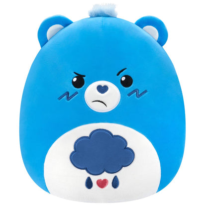 Bright blue Squishmallow Grumpy Bear 10-inch plush featuring the recognizable annoyed expression and a stitched rain cloud belly emblem