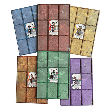 Five colourful, weathered board game player mats with grid patterns (blue, red, gold, green, purple), each displaying a character card