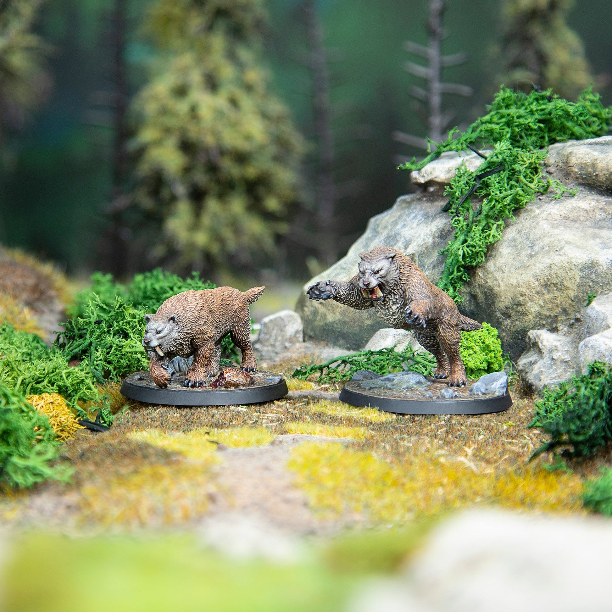 Miniatures of two saber-toothed cats in a forest- one guards a carcass as the other lunges with open mouth