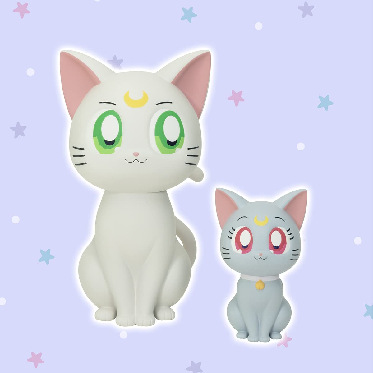 Two sitting Sailor Moon cat figures: white Artemis and light blue Luna, both with crescent moons, on a starry purple background
