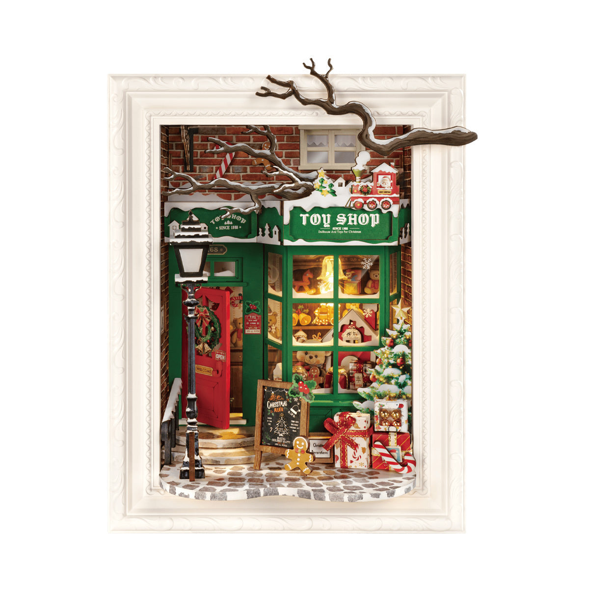 Framed 3D miniature diorama of a green Christmas Toy Shop facade, decorated with snow, gifts, and bright window displays