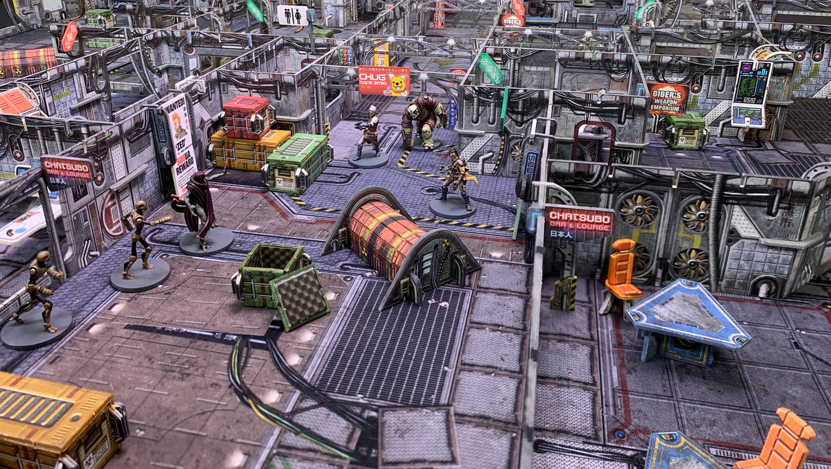 Miniature sci-fi wargame board with detailed cyberpunk terrain and several figures engaged in a tense skirmish.