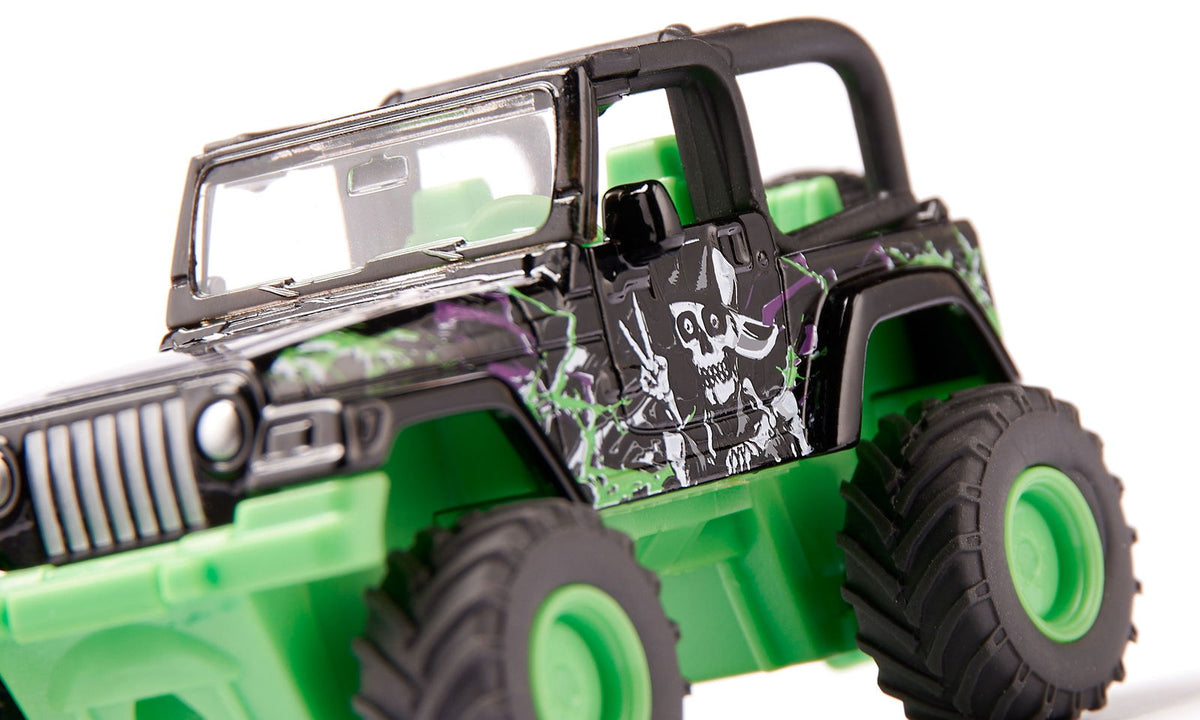 Close-up of a black and green Grave Digger mJeep Big Wheel toy with a skull and peace sign decal on the side