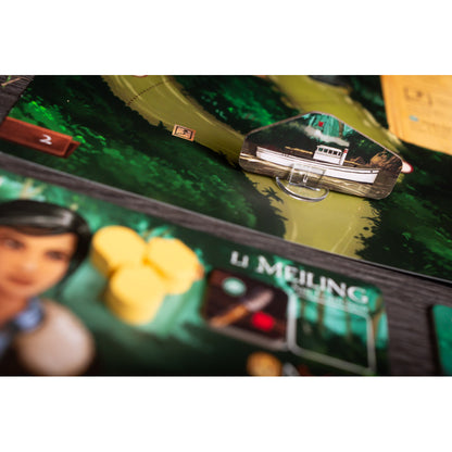 Board game: A steamboat token on a winding green jungle path, with a character card and yellow tokens in the foreground