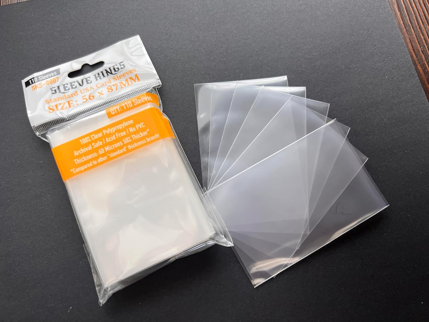 A package of "Sleeve Kings" 56x87mm clear card sleeves and several individual sleeves fanned out