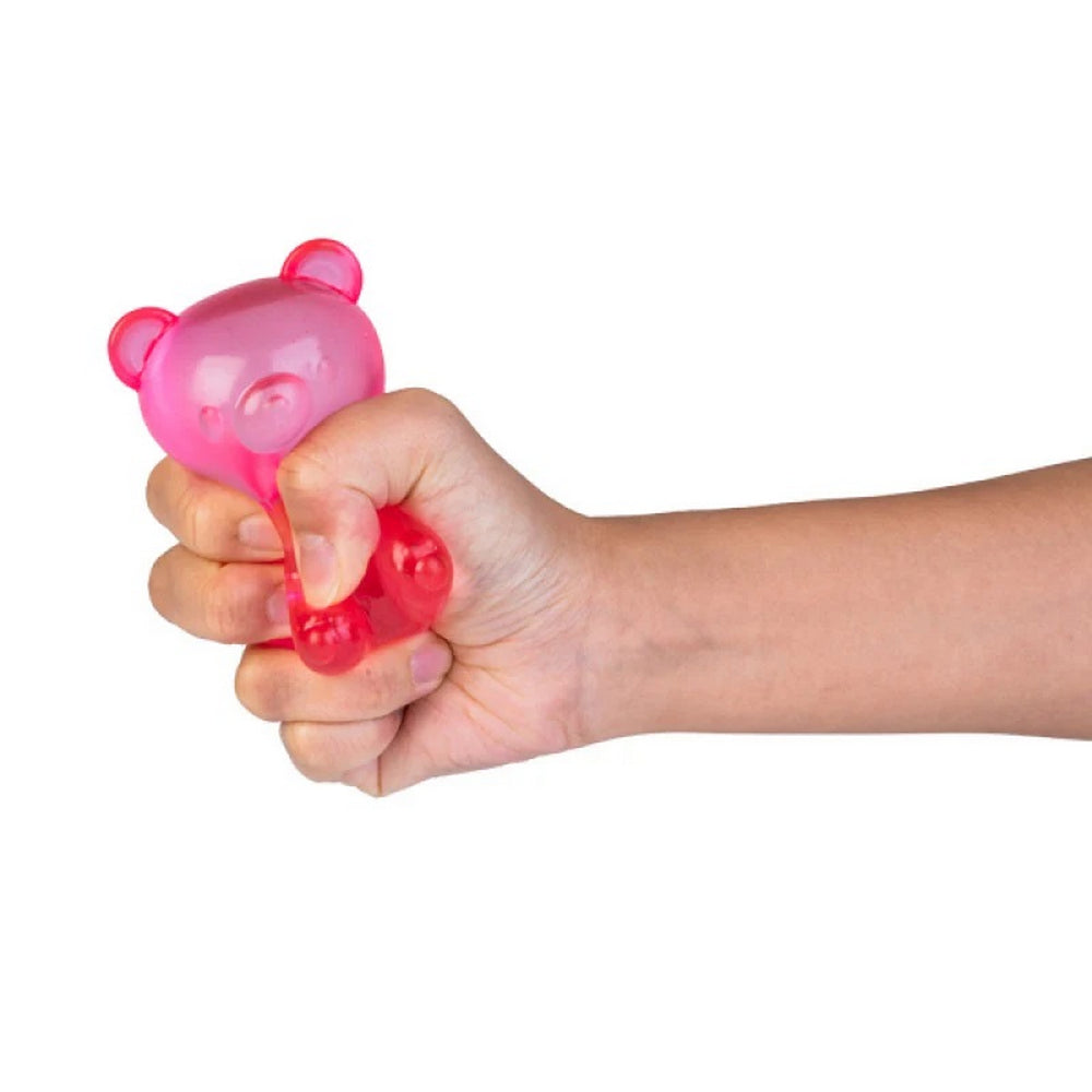 A hand squeezes a pink bear-shaped stress ball