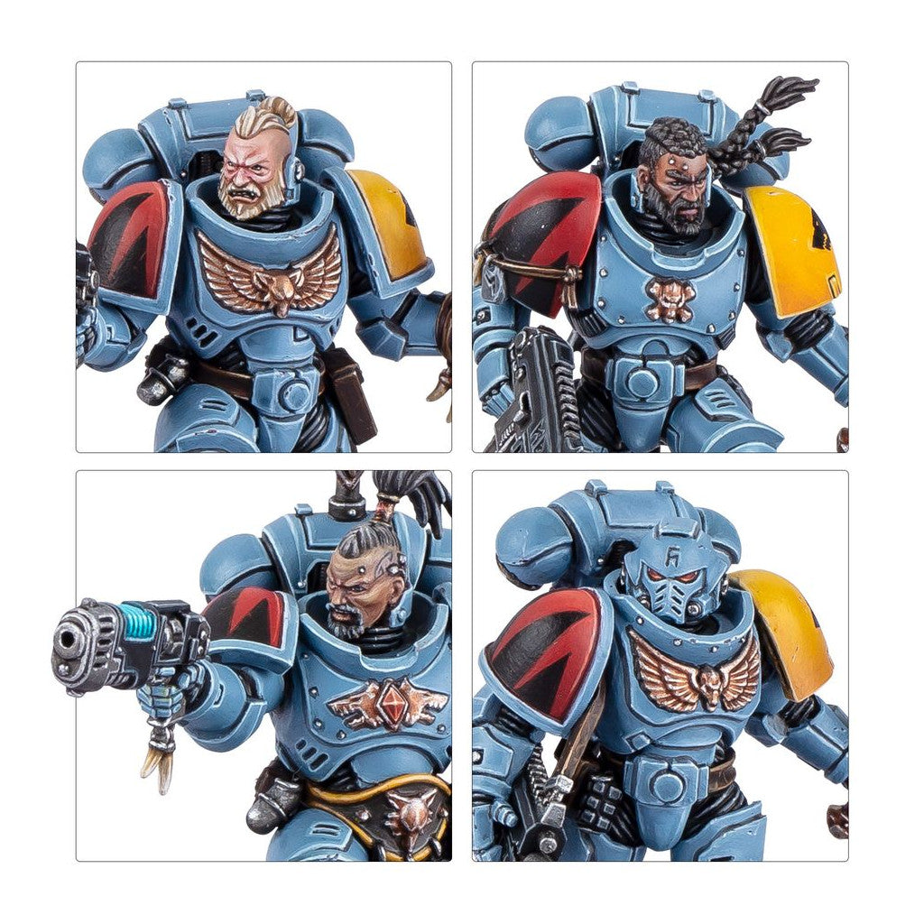 Four painted Space Wolves figures in blue-grey power armor, with bearded faces, a helmet, and a gun