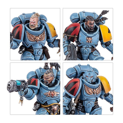 Four painted Space Wolves figures in blue-grey power armor, with bearded faces, a helmet, and a gun
