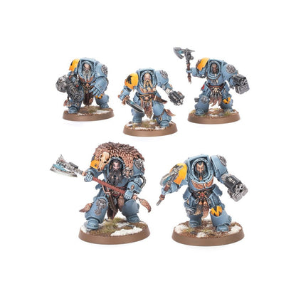 Five painted Warhammer 40k Space Wolves miniatures in grey armor, adorned with fur and wielding axes and guns