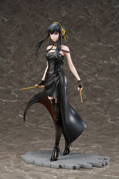A Spy X Family Yor Forger figure in a black dress, holding two golden needles, standing on a grey stone-textured base against a dark background