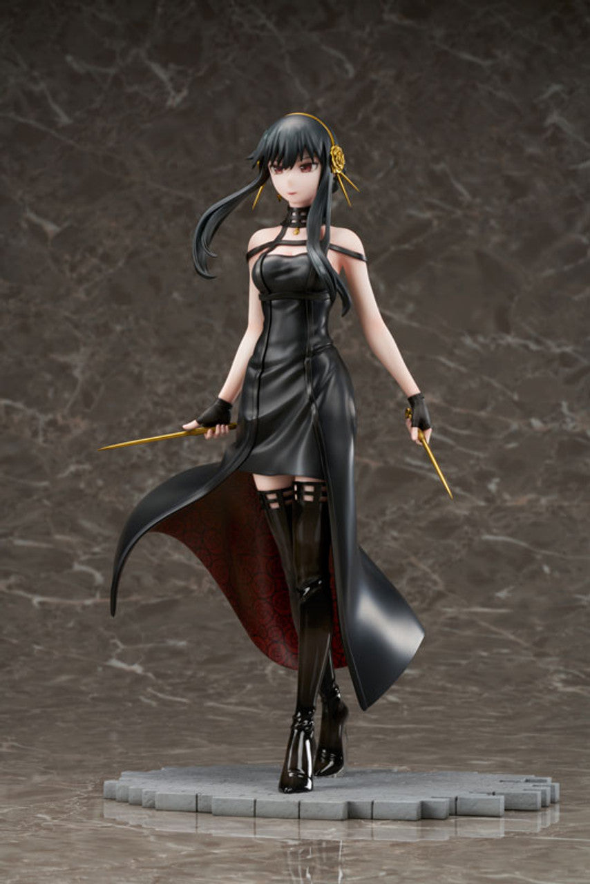 A Spy X Family Yor Forger figure with long black hair, wearing a black dress, thigh-high boots, and holding two gold stiletto weapons on a grey base