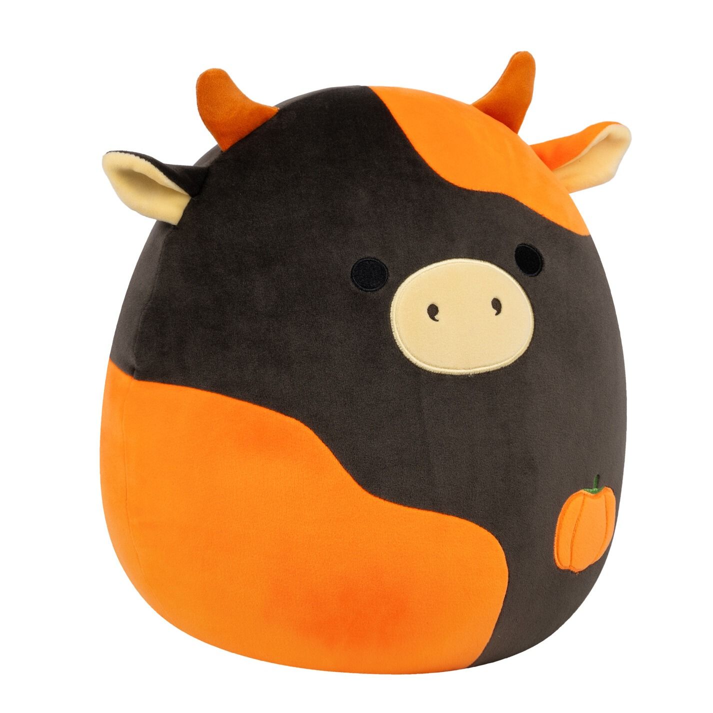 A Halloween-themed black and orange cow Squishmallow plush toy with a small pumpkin on its side