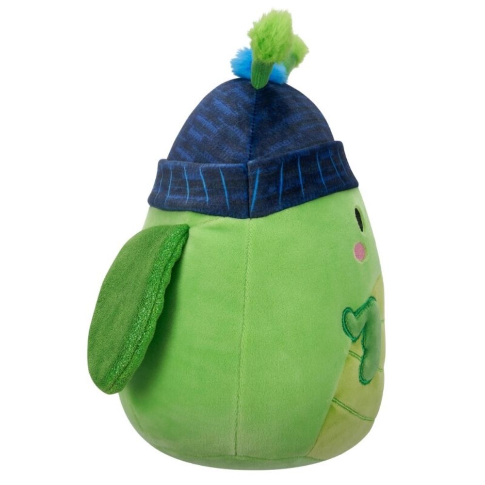 Green plush toy (likely a turtle) wearing a blue knit beanie with a green pom-pom, viewed from the side
