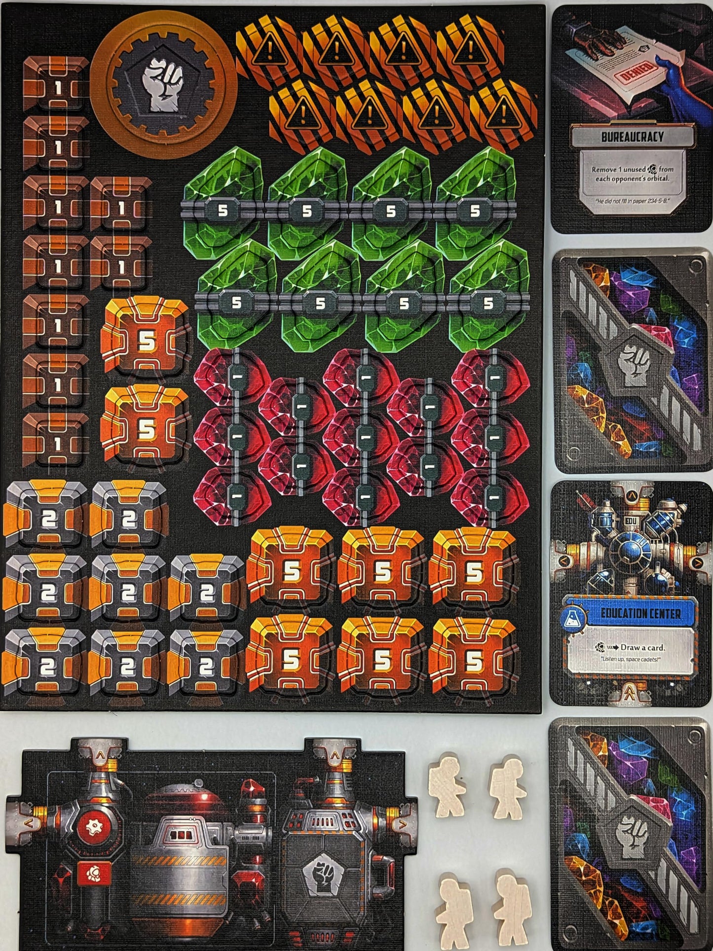 Star Scrappers: Orbital board game components spread out: colorful crystal and crate tokens, sci-fi cards, a factory tile, and astronaut meeples