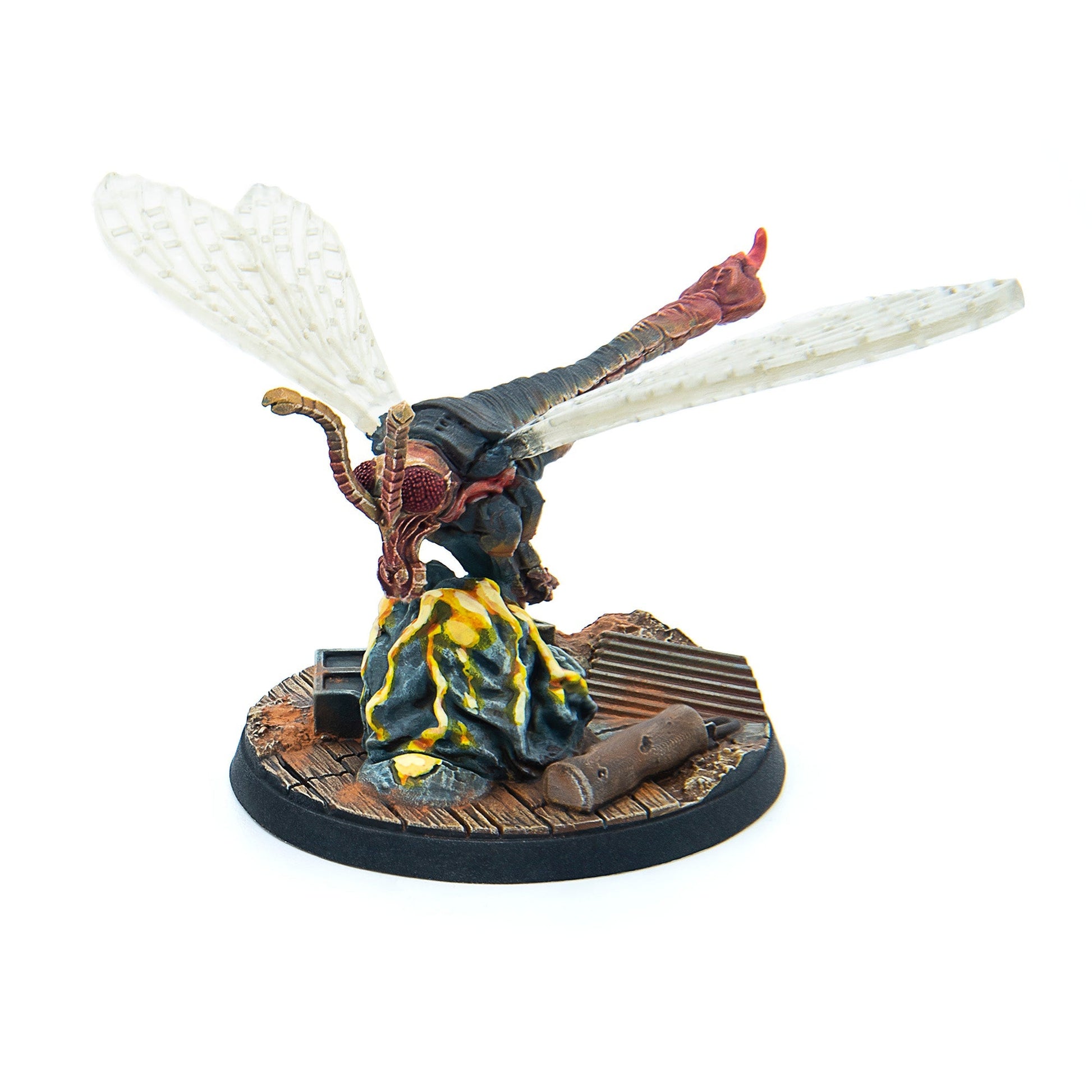 Painted miniature of a large dark insect creature with clear wings and red eyes, poised on a textured base with glowing yellow details