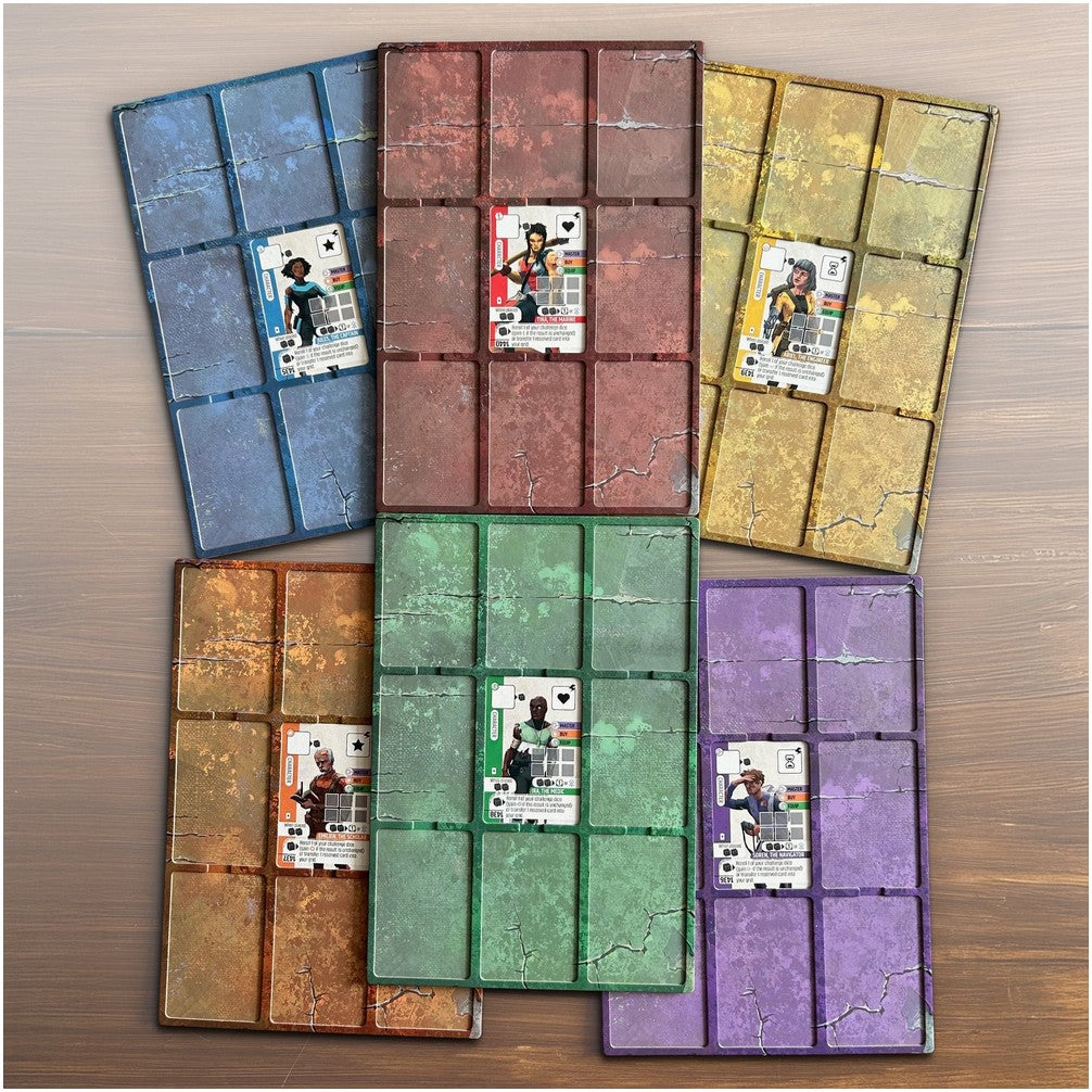 Six colourful, distressed board game player mats, each holding a character card, fanned on a wood table