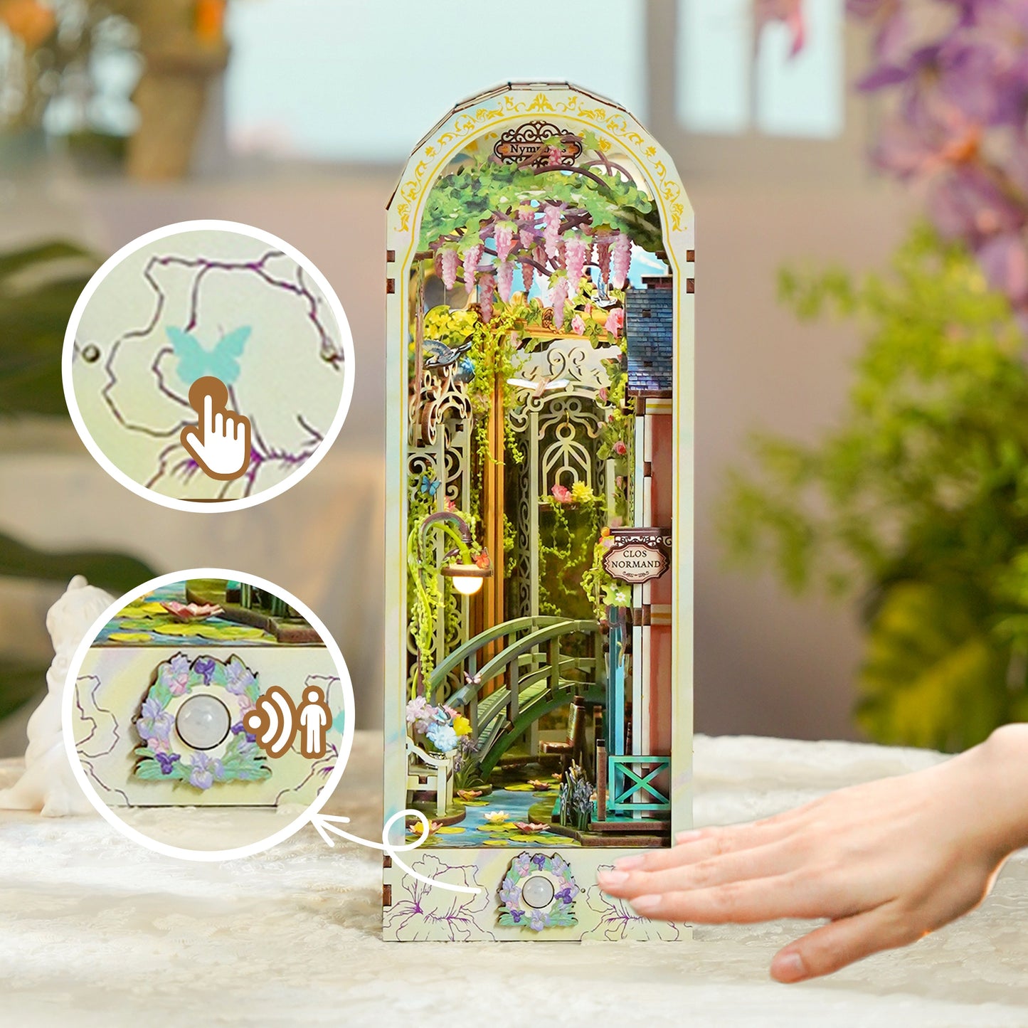 Detailed book nook miniature of a wisteria garden and bridge. Insets emphasize touch-activated light and motion sensors