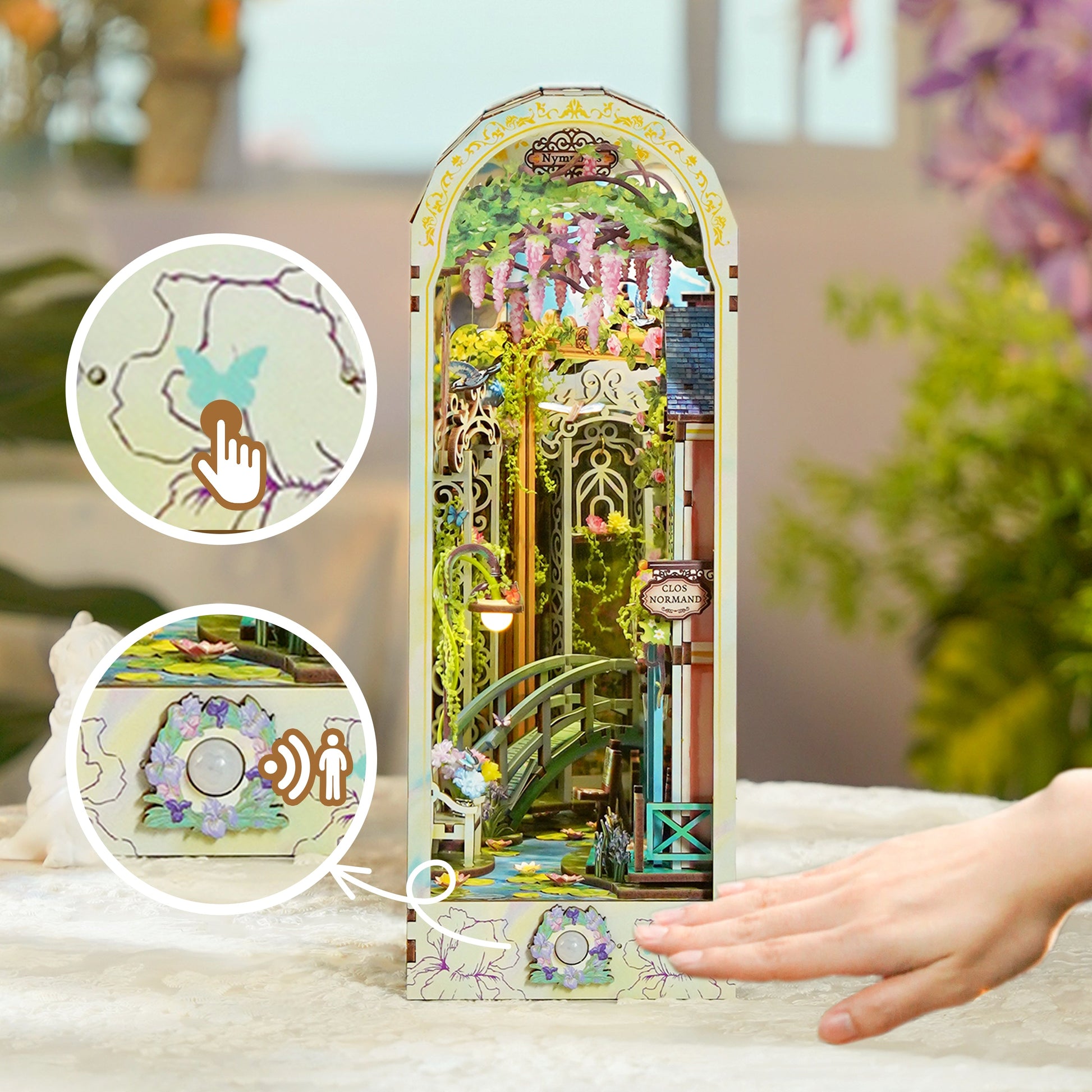 Detailed book nook miniature of a wisteria garden and bridge. Insets emphasize touch-activated light and motion sensors