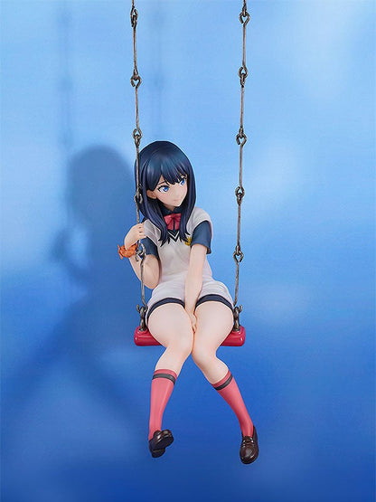 Anime figure of a girl with black hair sitting on a red swing wearing a white and blue school uniform and pink socks