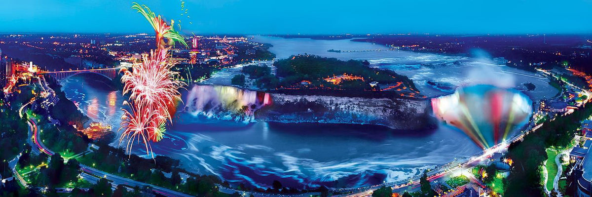 Fireworks and hot air balloon over illuminated Niagara Falls at dusk