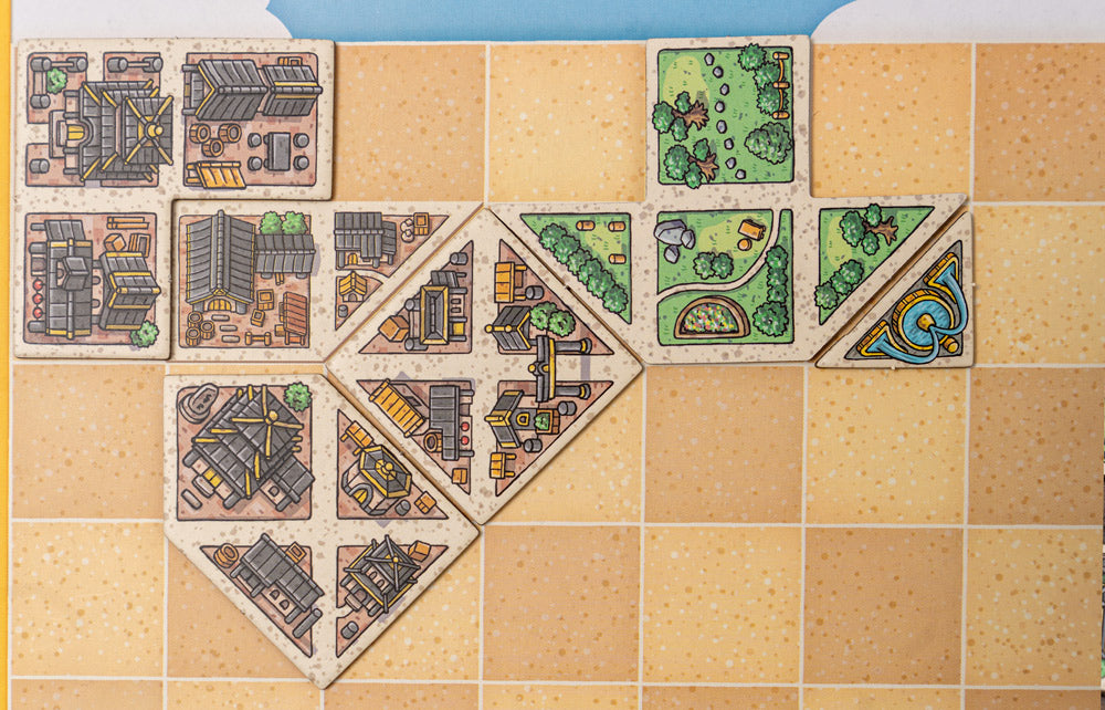 Tangram City components laid out neatly showing tiles, cards, and game board