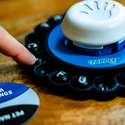 A finger presses a letter on the blue and black Tapple mini game. The white central timer button with a hand symbol is visible
