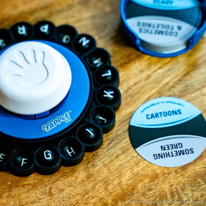 Tapple Mini game board with a white hand icon, alphabet letters, and a "CARTOONS" category card