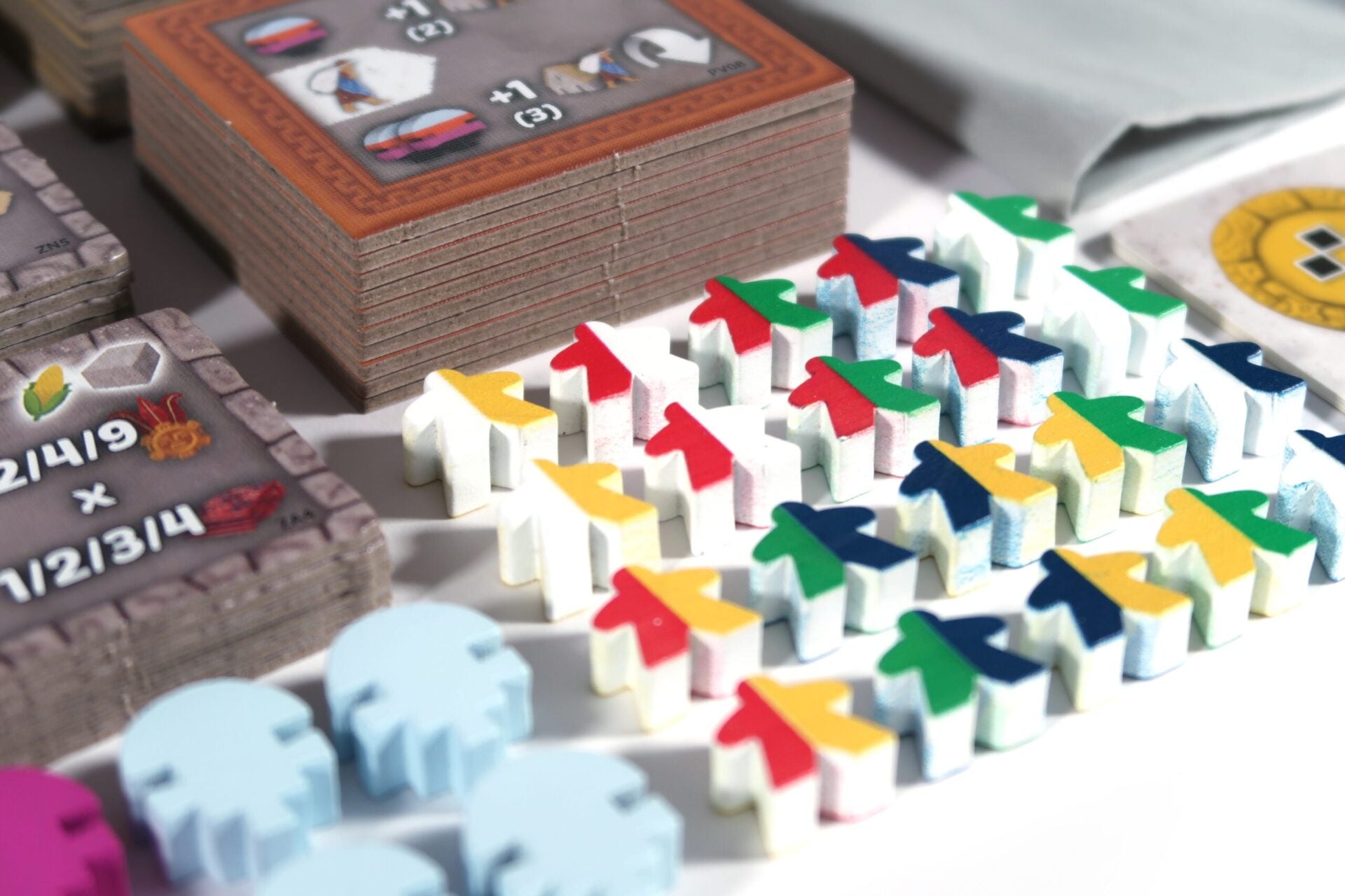 Close-up of Tawantinsuyu expansion miniatures and tokens