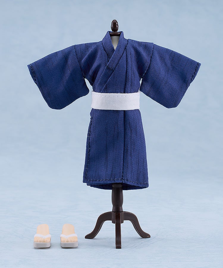 Doll-sized dark blue yukata with white obi on a mannequin, next to two tiny geta sandals