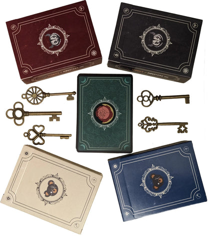 Four game boxes (red, black, beige, blue) with monster/bear emblems, five antique keys, and a rose-emblazoned card on white