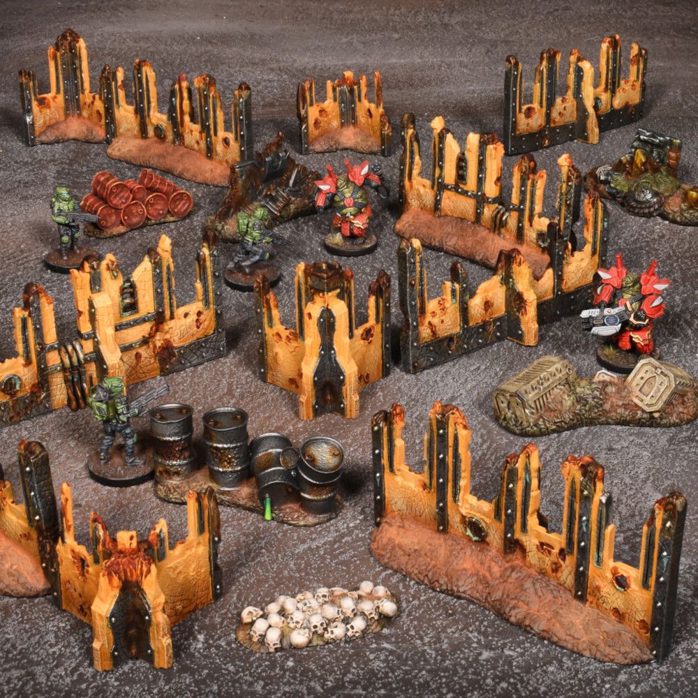 A miniature wargaming battlefield with ruined structures, barrels, green soldiers, and red mechs