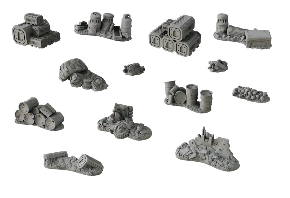 Twelve gray miniature wargaming terrain pieces depicting industrial junk, barrels, tires, crates, ruins, and human skulls