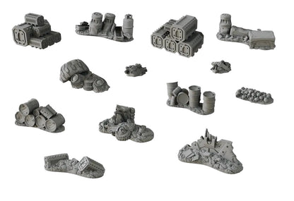 Twelve gray miniature wargaming terrain pieces depicting industrial junk, barrels, tires, crates, ruins, and human skulls