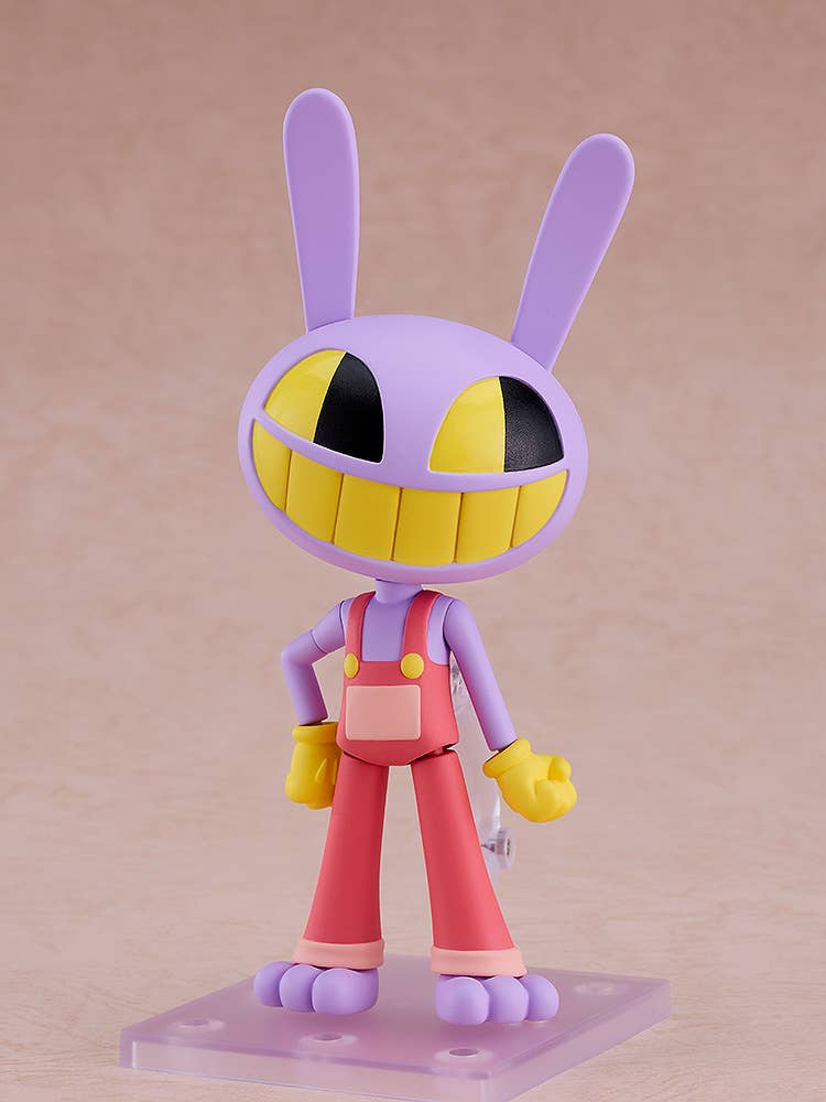 A purple rabbit character figure with a wide yellow grin and black eyes, wearing red overalls and yellow gloves, standing