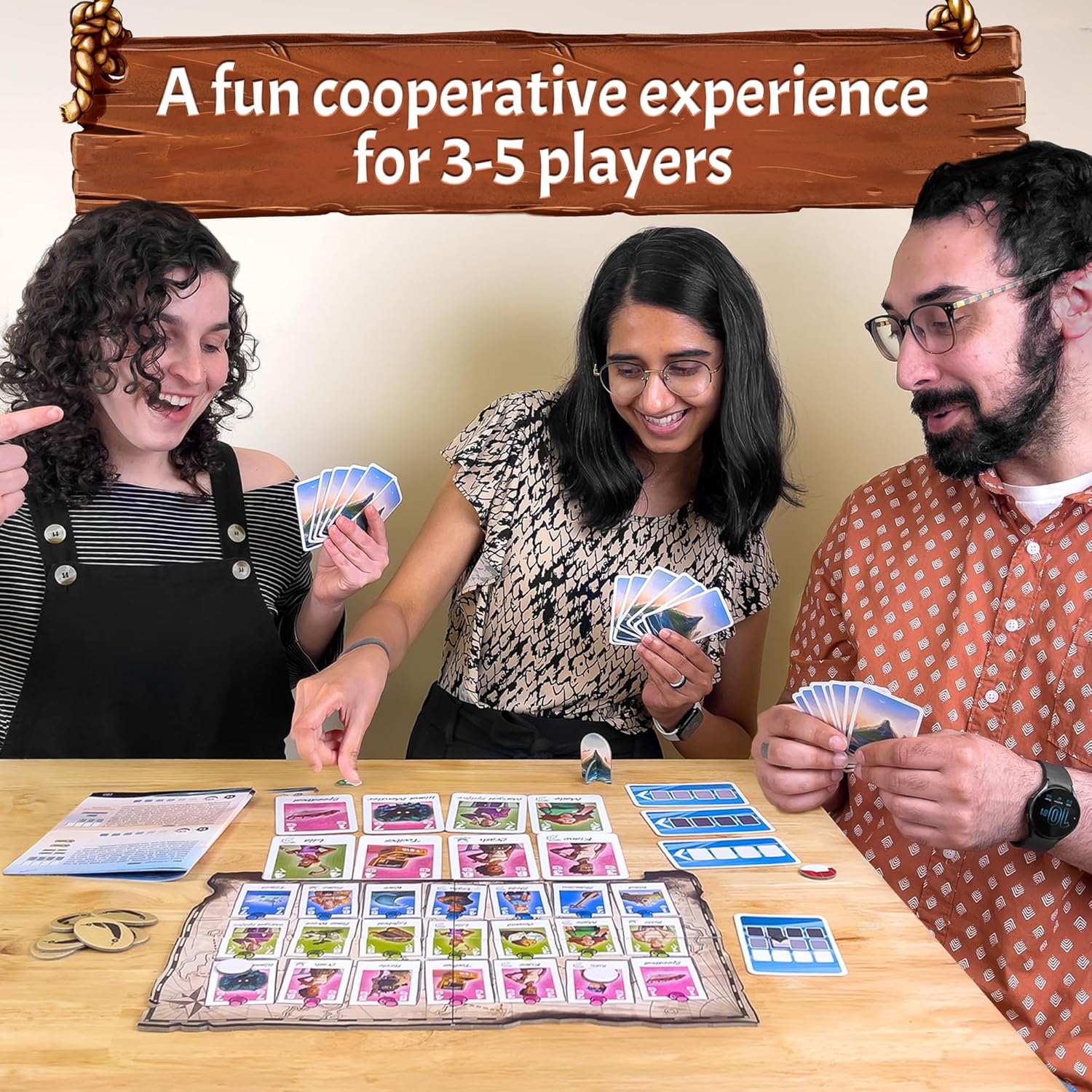 Three happy people playing a cooperative board game with cards & map on a wooden table