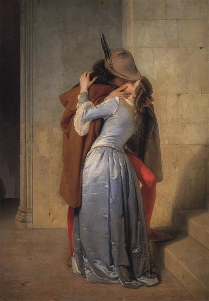 A man in a feathered hat and a woman in a blue dress passionately embrace and kiss against a stone wall