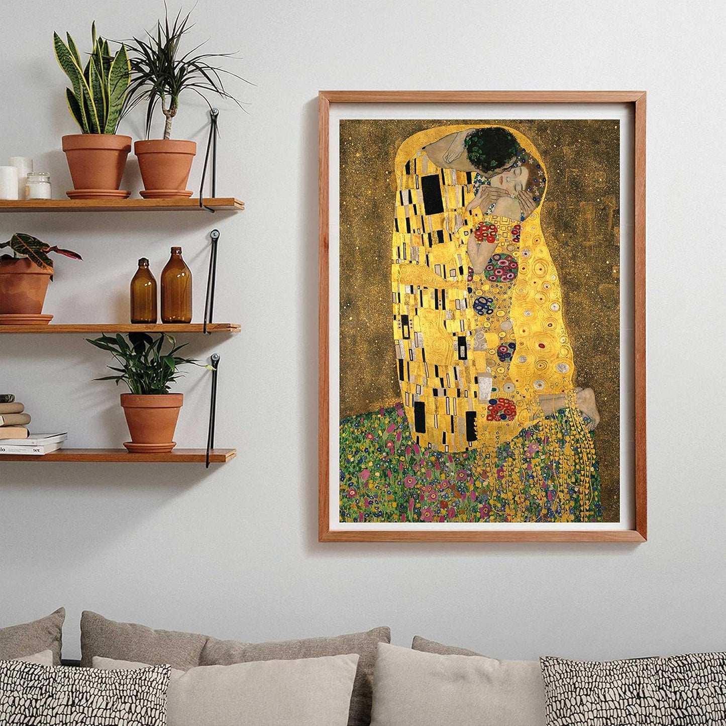 A framed print of Klimt's 'The Kiss,' showing a gold-patterned couple embracing, hangs on a light wall