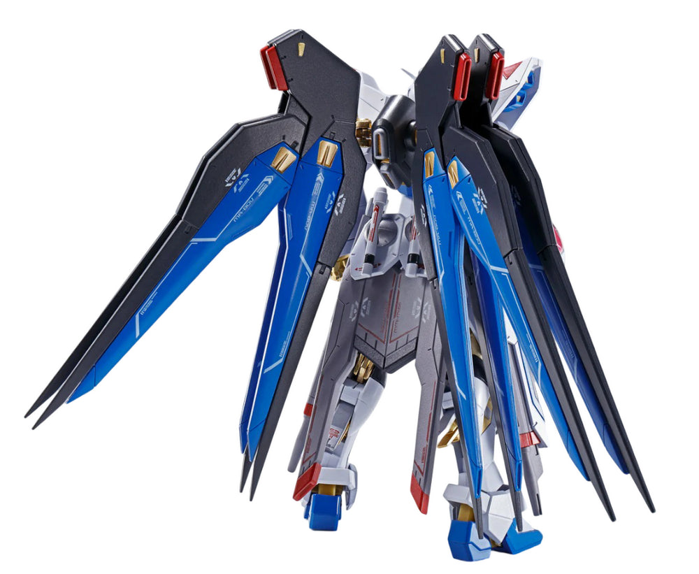 Back view of a detailed white, blue, and black Freedom Gundam model with deployed wings